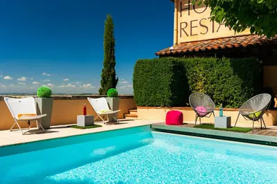 a swimming pool with chairs and a swimming pool at Cap de Castel in Puylaurens