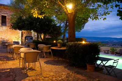 a patio with tables and chairs and a tree at Cap de Castel in Puylaurens