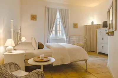 a bedroom with a bed and a table with a candle on it at Cap de Castel in Puylaurens
