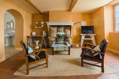 a living room with two chairs and a tv at Cap de Castel in Puylaurens