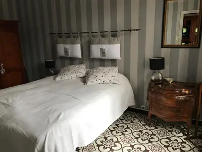 a bedroom with a white bed and a mirror at Le Mazagran proche du centre ville et 15 mn de la plage in Narbonne