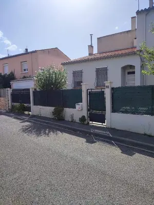a white house with a fence on a street at Le Mazagran proche du centre ville et 15 mn de la plage in Narbonne
