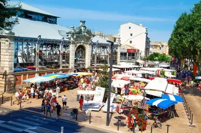 a group of people walking around a market with umbrellas at Le Mazagran proche du centre ville et 15 mn de la plage in Narbonne