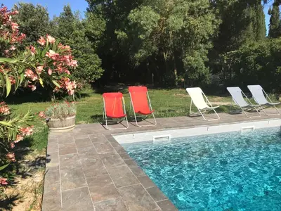 a group of chairs sitting next to a swimming pool at Maison Majorelle in Moussoulens