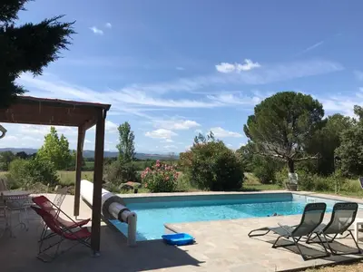 a swimming pool with chairs and a gazebo at Maison Majorelle in Moussoulens