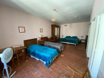 a bedroom with two beds and a table and a desk at La Marelle chambre d hôtes à 500m du Canal du Midi in La Redorte