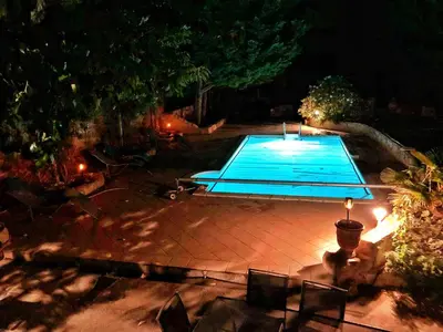 a swimming pool in a backyard at night at Pradines in Saint-André-de-Roquelongue