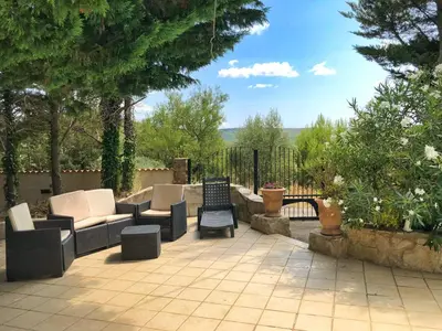 a patio with couches and chairs on a patio at Pradines in Saint-André-de-Roquelongue