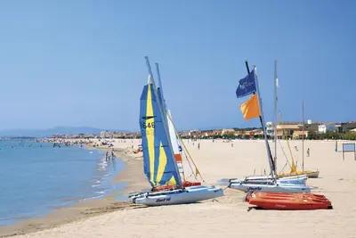 three sailboats on a beach with people in the water at Pradines in Saint-André-de-Roquelongue