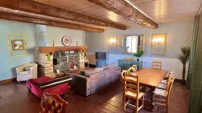 a living room with a couch and a table and a fireplace at Pradines in Saint-André-de-Roquelongue