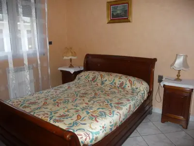 a bedroom with a bed and two tables and a lamp at Havre de Paix Centre ville Narbonne, T3 confortable, près de l'ARENA et du GRAND BUFFET in Narbonne