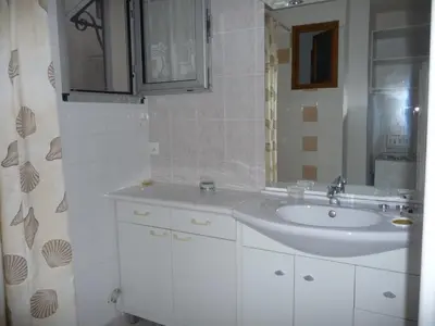 a white bathroom with a sink and a mirror at Havre de Paix Centre ville Narbonne, T3 confortable, près de l'ARENA et du GRAND BUFFET in Narbonne