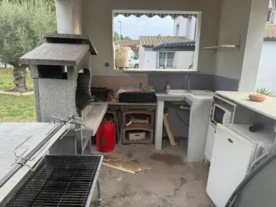 a kitchen with a stove and a sink and a window at Nid douillet in Villemoustaussou