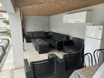 a patio with a couch and chairs and a refrigerator at Nid douillet in Villemoustaussou
