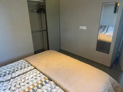 a bed in a small room with a mirror at Nid douillet in Villemoustaussou