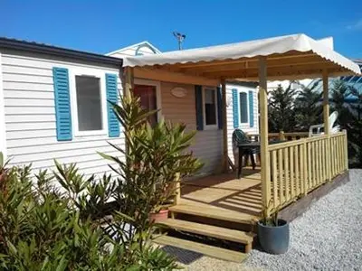 a small house with a porch and a deck at Camping Sigean in Sigean