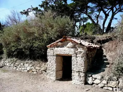 a small stone building with a door on a hill at Camping Sigean in Sigean
