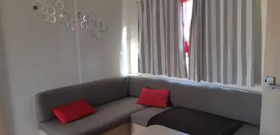 two red pillows sitting on a couch in a room at Camping Sigean in Sigean