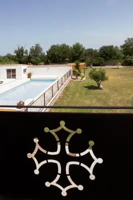 a view of a swimming pool from a window at Gîtes Chantelauze in Narbonne