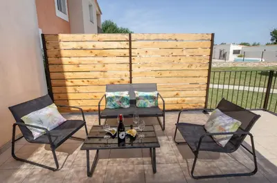 two chairs and a table on a patio at Gîtes Chantelauze in Narbonne