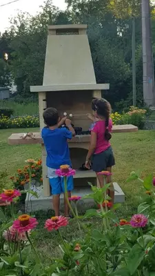 two children standing in front of a bird house at Gîte de Marie in Burlats