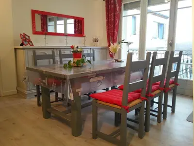 a kitchen with a wooden table with chairs and a dining room at Gîte de Marie in Burlats