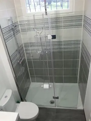 a bathroom with a glass shower with a toilet at Gîte de Marie in Burlats