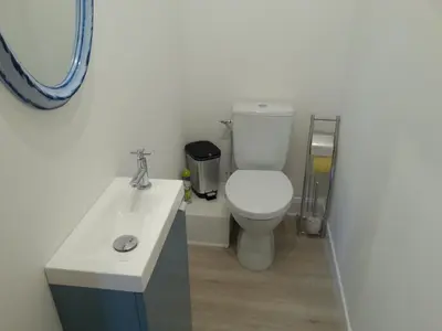 a bathroom with a white toilet and a sink at Gîte de Marie in Burlats