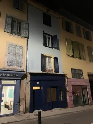 a building with a blue door on a street at la maison des chapeliers in Carcassonne
