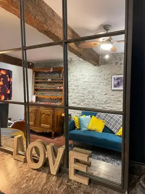 a living room with a blue couch and a large mirror at la maison des chapeliers in Carcassonne