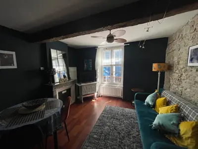 a living room with a blue couch and a table at la maison des chapeliers in Carcassonne