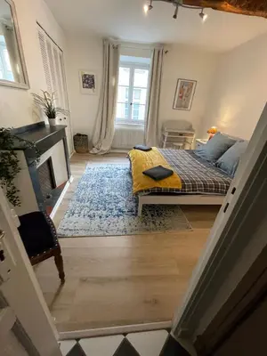 a bedroom with a bed with a yellow blanket at la maison des chapeliers in Carcassonne