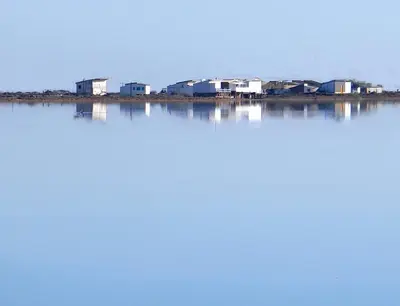 a large body of water with houses in the background at La petite maison bleue in Gruissan