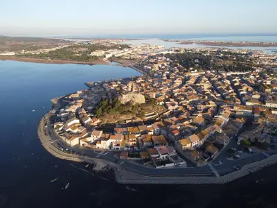an aerial view of a city next to the water at La petite maison bleue in Gruissan