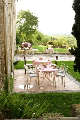 a patio with a pink table and chairs at La Bergerie de l'etang in Montels