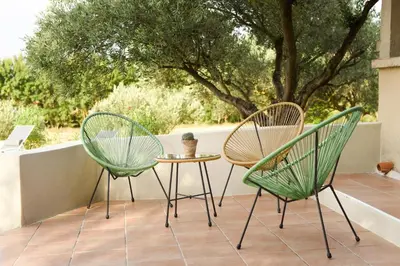 two chairs and a table on a patio at La Bergerie de l'etang in Montels
