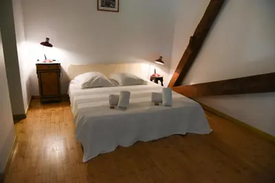 a bedroom with a bed with two candles on it at La Bergerie de l'etang in Montels