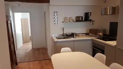 a small kitchen with a table and chairs in it at Gîtes Les 3 Tours in Carcassonne