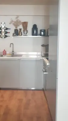 a white kitchen with a sink and a counter at Gîtes Les 3 Tours in Carcassonne