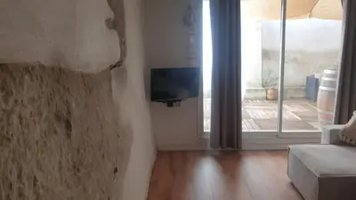 a room with a wall with a tv and a window at Gîtes Les 3 Tours in Carcassonne