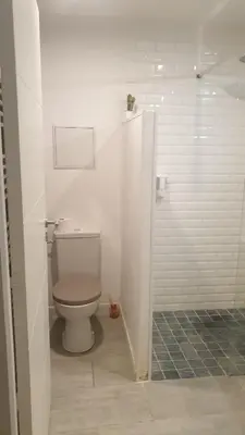 a white bathroom with a toilet and a shower at Gîtes Les 3 Tours in Carcassonne