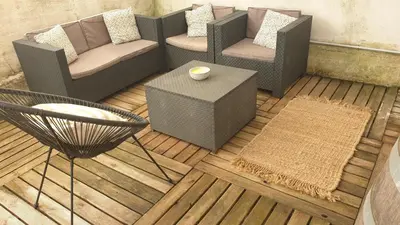 a living room with chairs and a table and a rug at Gîtes Les 3 Tours in Carcassonne