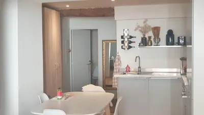 a white kitchen with a table and a sink at Gîtes Les 3 Tours in Carcassonne