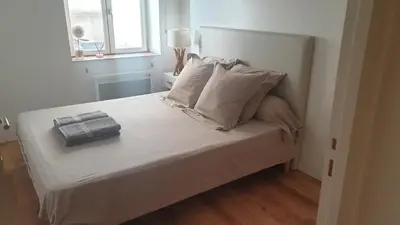 a bed with white sheets and pillows in a room at Gîtes Les 3 Tours in Carcassonne