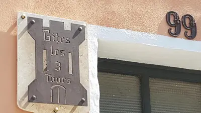a sign on the side of a building with a window at Gîtes Les 3 Tours 2 in Carcassonne