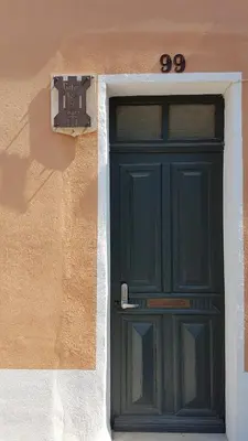 a green door on the side of a building at Gîtes Les 3 Tours 2 in Carcassonne