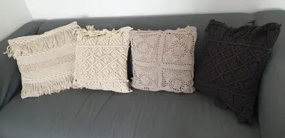 three white pillows are sitting on a couch at Gîtes Les 3 Tours 2 in Carcassonne