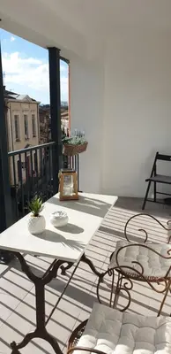 a patio with a table and chairs on a balcony at Gîtes Les 3 Tours 2 in Carcassonne