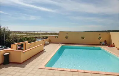a swimming pool on top of a house with a patio at Nice Apartment In Gruissan With Kitchen in Gruissan