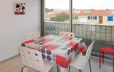 a table and chairs in a room with a window at Nice Apartment In Gruissan With Kitchen in Gruissan